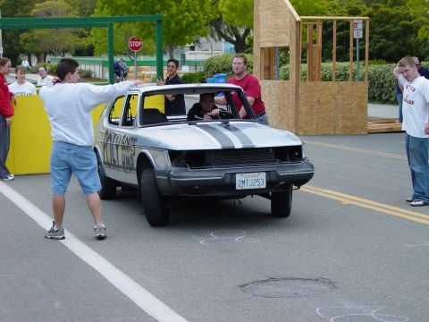 1999 Jeep Grand Cherokee - A silver sedan with racing stripes is prepared for an event, with people gathered around.