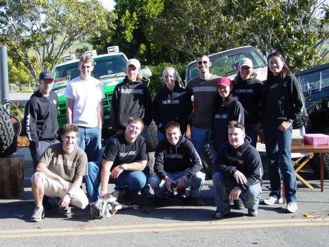 1999 Jeep Grand Cherokee - A group of people gathered around several off-road vehicles outdoors.