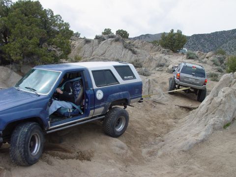 1999 Jeep Grand Cherokee - A blue off-road SUV is being towed by a silver Jeep Grand Cherokee on a rocky trail.