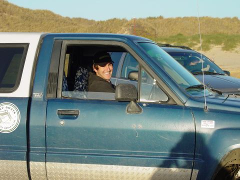 1999 Jeep Grand Cherokee - Man in a blue Toyota pickup truck with a camper shell, with another vehicle behind him.