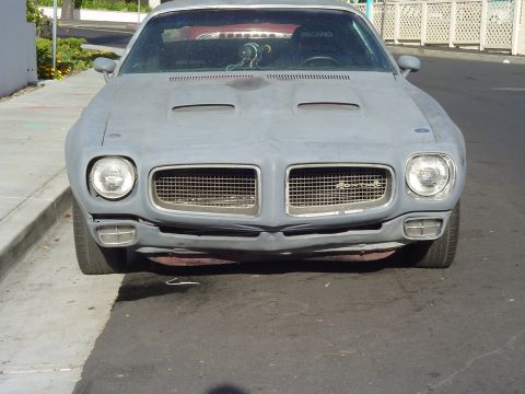1970 Pontiac Firebird - Front view of a 1970 Pontiac Firebird in primer, showing its distinctive grille and hood scoops.