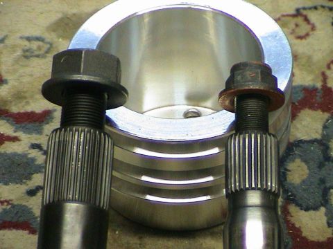 1979 Ford Bronco - Close-up of two splined shafts and bolts, positioned before a metal ring. These look like automotive components.