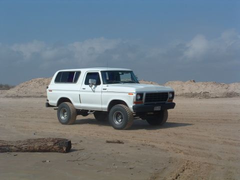 1993 Ford Bronco - This white 1978 Ford Bronco is shown in a 3/4 front view on a sandy landscape.