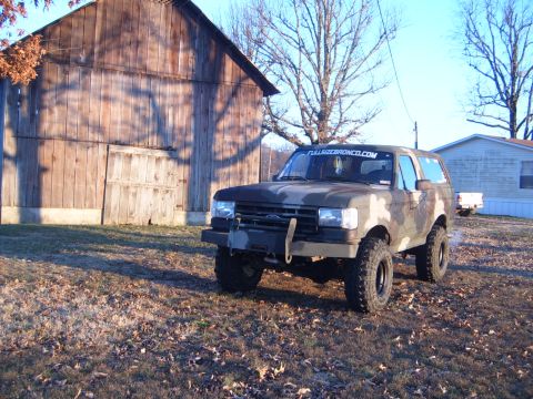1988 Ford Bronco - This 1988 Ford Bronco is parked in front of a rustic wooden barn under a clear sky.