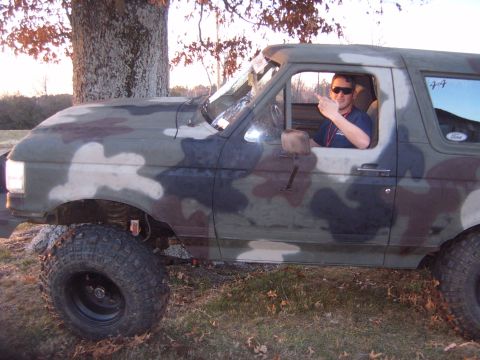 1988 Ford Bronco - Camouflaged 1988 Ford Bronco parked outdoors with a driver inside.