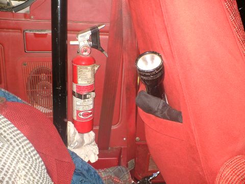 1989 Ford Bronco - Interior view showing a fire extinguisher and a flashlight stored in the vehicle.