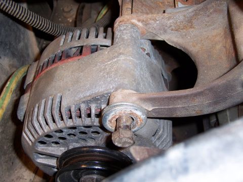 1983 Ford Bronco - This is a close-up view of a vehicle's alternator, showing its pulley and mounting hardware.