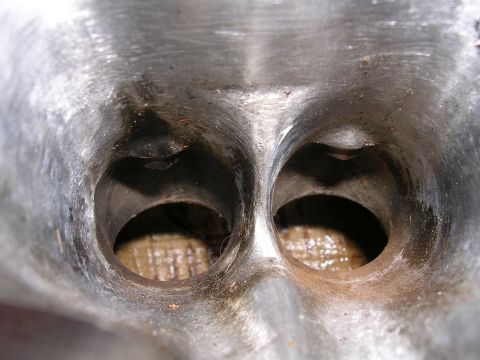 1996 Ford Probe - The intake ports of an engine cylinder head show signs of wear and accumulated residue.