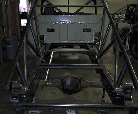 1977 Ford F-150 - The rear section of a truck chassis is shown with a custom-built roll cage structure surrounding it.