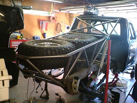 1977 Ford F-150 - This modified 1977 Ford F-150 is in a garage, undergoing repairs with its rear end elevated on stands.