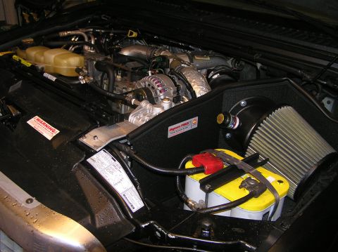 2000 Ford Excursion - Engine bay components including a battery, air filter, and engine block are visible in this photo.