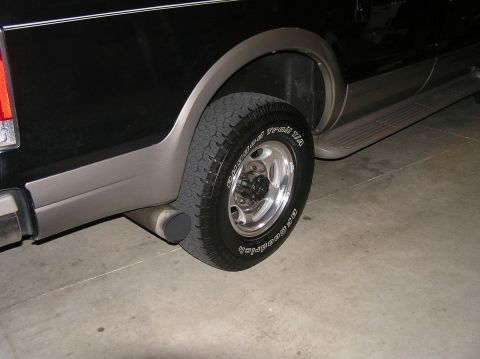 2000 Ford Excursion - The side profile of a 2000 Ford Excursion shows its rear wheel, exhaust pipe, and two-tone paint scheme.