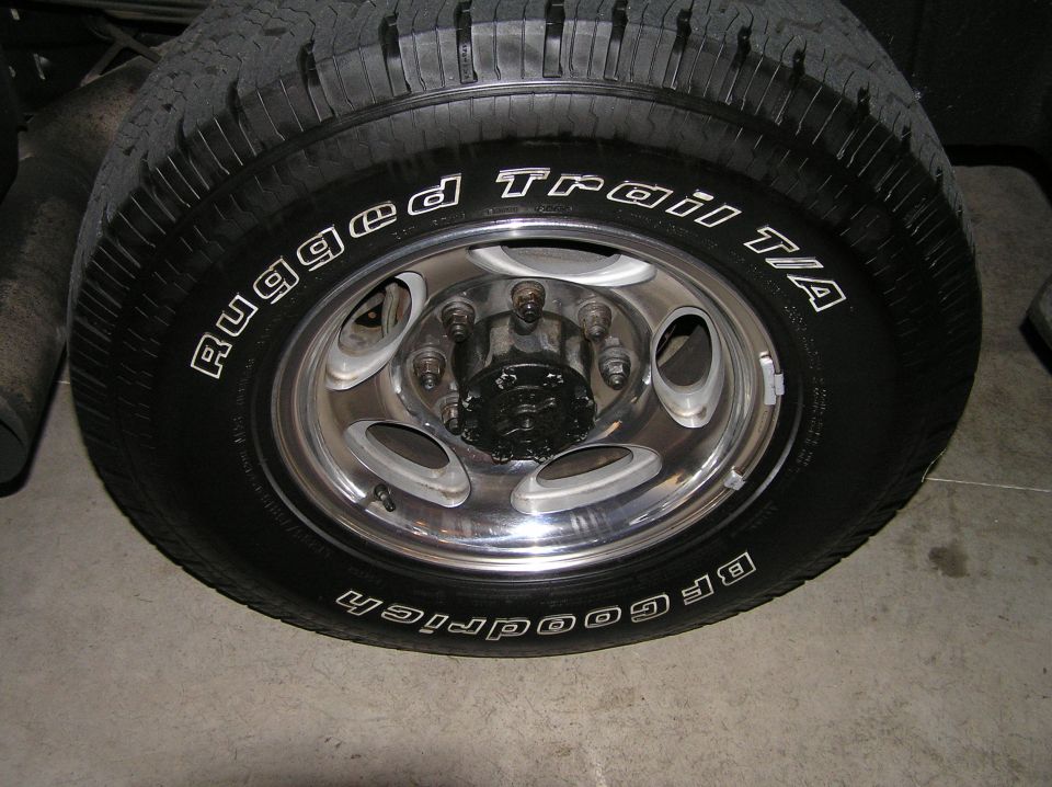 Polished alloy wheel with BFGoodrich Rugged Trail T/A tire on concrete floor