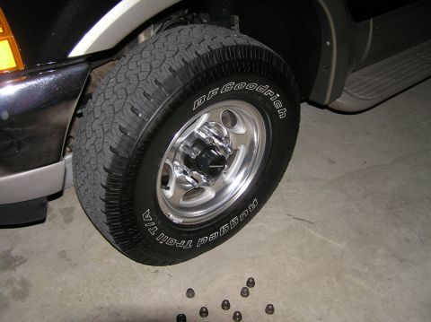 2000 Ford Excursion - Close-up of chrome lug nuts on a 2000 Ford Excursion wheel, with BFGoodrich tires and loose lug nuts on the ground.