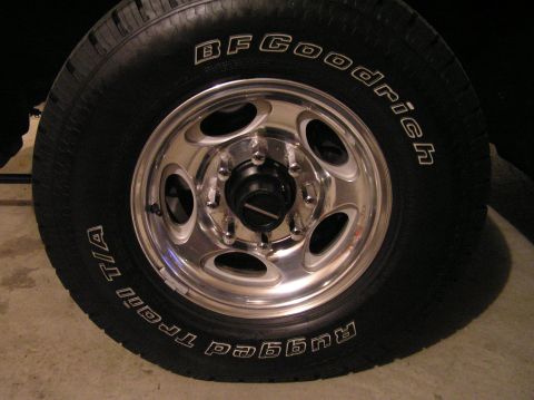 2000 Ford Excursion - A close-up view of a BFGoodrich Trail T/A tire mounted on a chrome wheel.