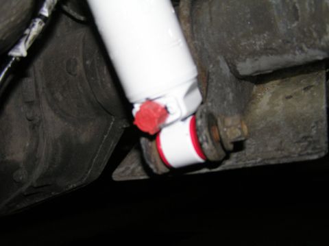 2000 Ford Excursion - Close-up of a new rear shock absorber installation with red and white bushings.