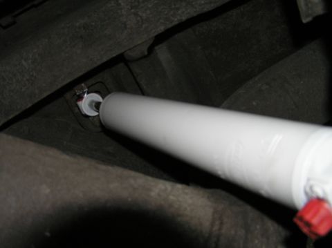 2000 Ford Excursion - Close-up of a white shock absorber attached to the underside of a vehicle.