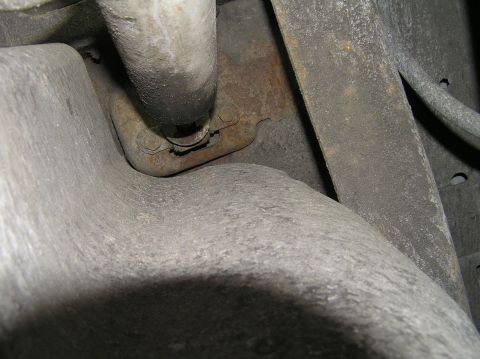 2000 Ford Excursion - Close-up view of a rusty bracket and pipe, likely part of a vehicle's undercarriage.