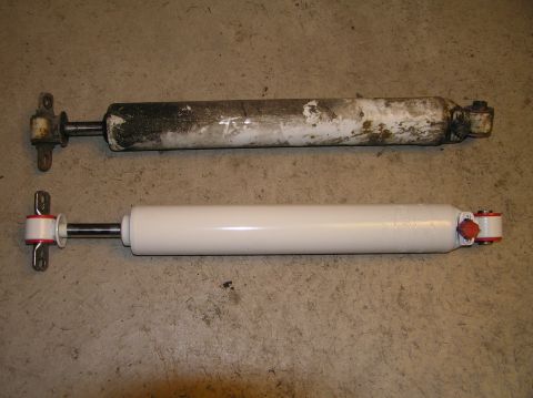2000 Ford Excursion - Comparison of a used and a new shock absorber, likely for a vehicle suspension upgrade.