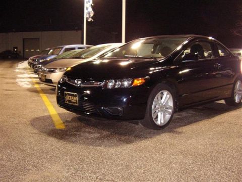 1997 Ford Taurus - A black coupe with a "TEAM" license plate is parked in a lot, with other vehicles in the background.