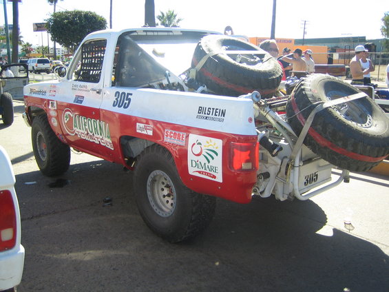 Rear three-quarter view of race truck #305 with two spare tires mounted at the rear