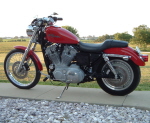 2002 Harley-Davidson Sportster Custom - Side view of a red 2002 Harley-Davidson Sportster Custom motorcycle.