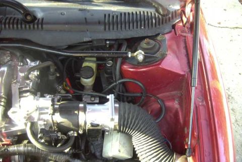 1997 Ford Taurus - Close-up of a modified engine bay, showing intake components and brake fluid reservoir.