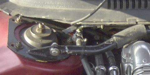 1997 Ford Taurus - Engine bay detail showing a strut mount and various hoses and clamps.