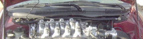 1997 Ford Taurus - Close-up view of a car's engine compartment, showing the intake system and various engine components.