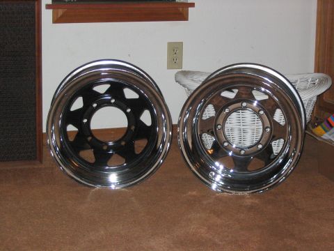 1995 Ford Bronco - Two aftermarket wheels are displayed, one with a black center and the other with a polished finish.