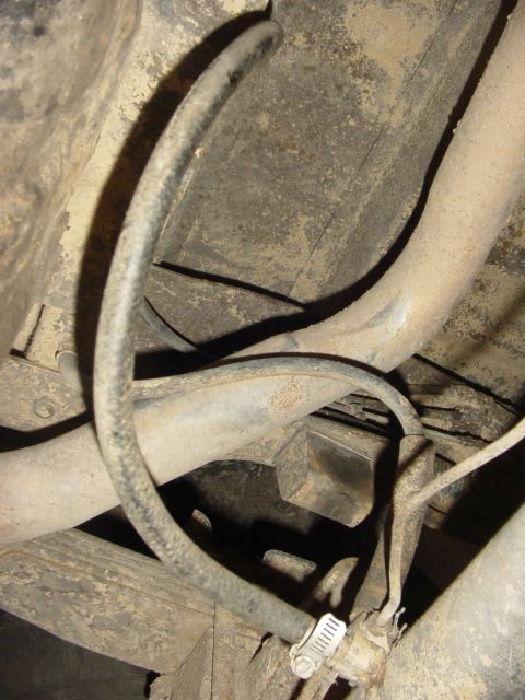 1989 Ford Bronco - Close-up of hoses and frame components visible from underneath a vehicle.