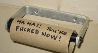 1994 Ford Bronco - A close-up of an empty cardboard toilet paper tube on a chrome bathroom holder, hand-lettered with a joke message in black marker. No vehic…