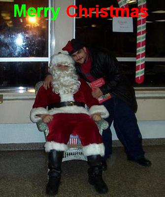 1994 Ford Taurus - Man dressed as Santa Claus sits in a chair while another man stands behind him, posing for a photo.