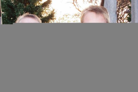 1986 Ford Bronco - Two individuals are captured in a selfie-style photo, with trees and a fence visible in the background.