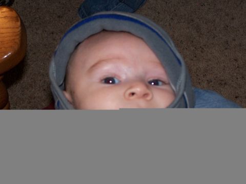 1986 Ford Bronco - A baby is captured in a close-up shot, wearing a grey hooded sweatshirt.