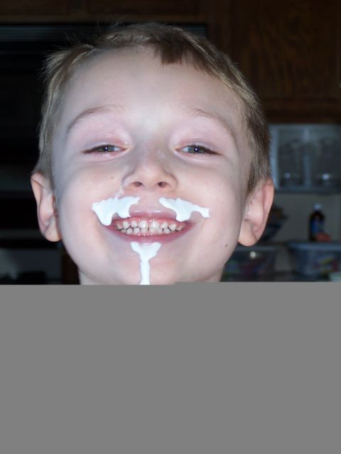 1986 Ford Bronco - A young child smiles with a white substance smeared around their mouth and nose.