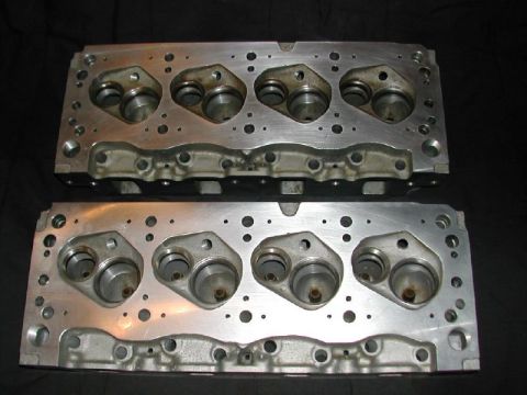 1971 Ford Mustang - Two aluminum engine cylinder heads are shown against a dark background.