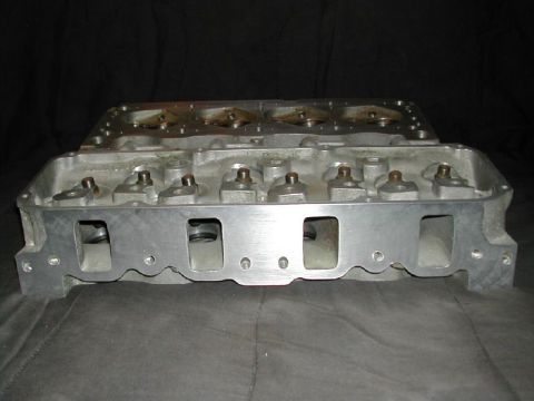 1971 Ford Mustang - An aluminum engine cylinder head is shown, likely for a performance application, with its intake and exhaust ports clearly visible.
