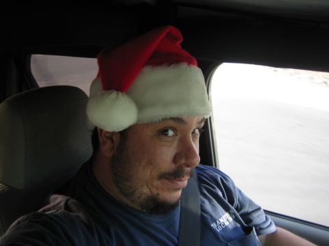 1968 Ford Mustang - A man in a Santa hat is driving and looking back at the camera.