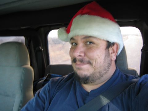1968 Ford Mustang - A man wearing a Santa hat smiles while seated inside a vehicle.