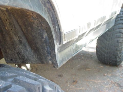 1986 Ford Bronco - Detail shot of a vehicle's fender well and tire, showing wear and tear.
