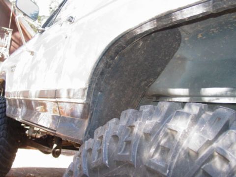 1986 Ford Bronco - This photo shows the wheel well and tire of a vehicle, with chrome trim on the side panel.