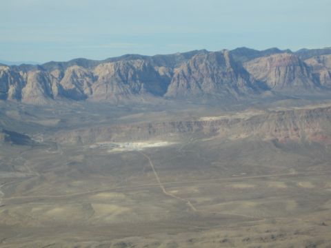 1968 Ford Mustang - A wide view of a desert landscape with mountains in the background under a pale blue sky.
