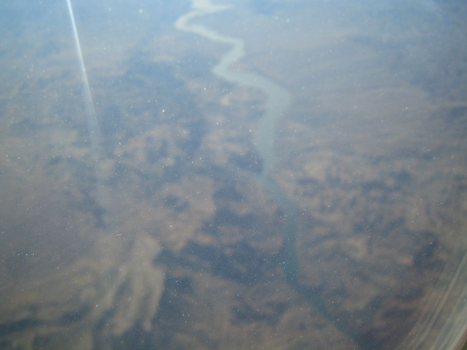 Aerial shot of a river snaking through a dry, textured landscape