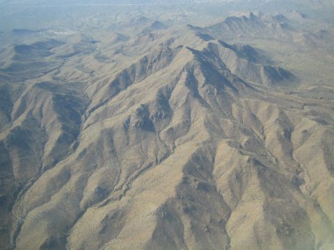 1968 Ford Mustang - An expansive view of , dry mountains from an aerial perspective, showing the texture of the terrain.