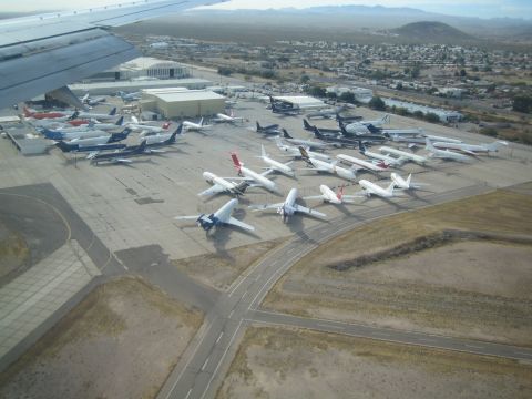 1968 Ford Mustang - An aerial view captures a vast collection of parked aircraft on an airport tarmac under a hazy sky.