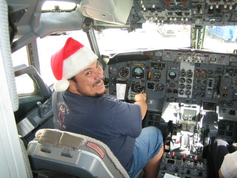 1968 Ford Mustang - A man in a Santa hat sits in the cockpit of an airplane, ready for a festive flight.