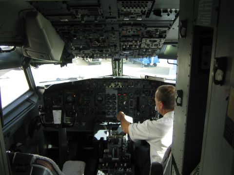 1968 Ford Mustang - A pilot sits in the cockpit, hands on the controls, surrounded by an array of instruments and switches.