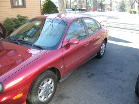 1998 Ford Taurus - This red 1998 Ford Taurus sedan is viewed from the front three-quarter angle.