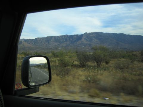 1968 Ford Mustang - View of a desert landscape from inside a vehicle, including a side mirror reflection.